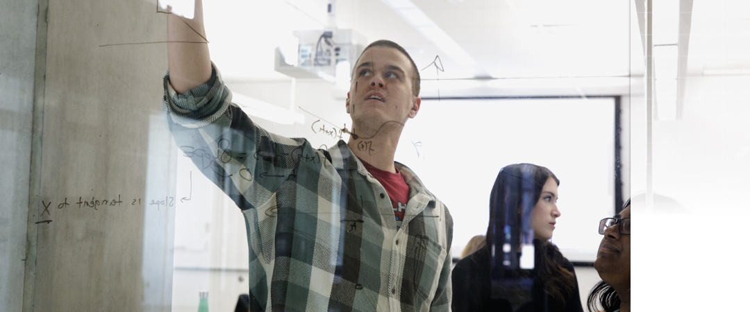 student writing on whiteboard