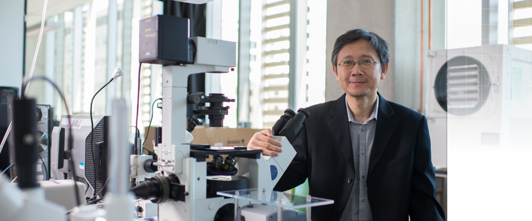 professor Li standing in front of microscope